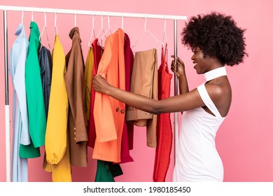 Shopping Concept. African American Female Choosing And Buying Clothes On Clothing Rack Standing In Studio On Pink Background. Fashion And Trends, Great Seasonal Sales - Powered by Shutterstock