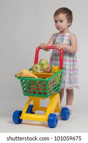 Shopping concept - child with shopping cart full with groceries