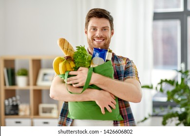 shopping, consumerism and people concept - smiling young man with food in bag at home - Powered by Shutterstock