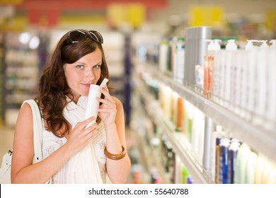 Shopping Cosmetics - Woman Smelling Bottle Of Shampoo In Drug-store