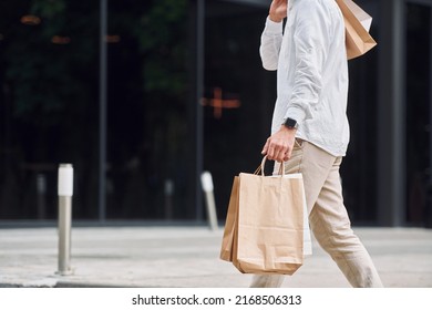 Shopping day. Stylish young man is outdoors with bags.