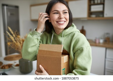 Shopping, delivery and purchase concept. Indoor image of joyful fashionable young woman holding cardboard box, unpacking furniture she ordered for new apartment, having excited happy facial expression - Powered by Shutterstock