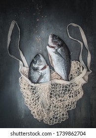 Shopping eco bag with two sea breams - dorado sea fish. Mediterranean cuisine. Overhead view with copy space.