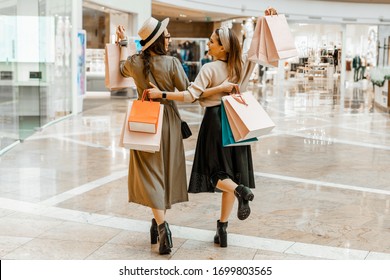 Shopping and entertainment, mall inside. Two beautiful girls with paper bags at the mall. The joy of consumption, Gift shopping, holiday