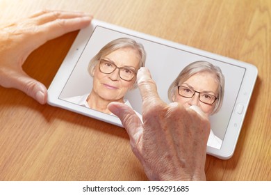 Shopping Eyeglasses Online Concept: Hands Of A Senior Woman Choosing Her New Glasses At Home On A Tablet Computer.