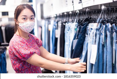 Shopping, Fashion, Style And People During Covid19 - Happy Woman Choosing Clothes Wearing Face Mask In Mall Or Clothing Store.Entrepreneur.Clothes Shop Costume Dress Fashion Store Style Concept.