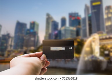 Shopping, Finances, Tourism, Travel, Concept. - Hands Tourist Young Man With Show Credit Card With The Merlion Background In Singapore.