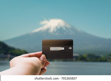 Shopping, Finances, Tourism, Travel, Concept. - Hands Young Man With Show Credit Card Over Mt.Fuji Background In Japan.