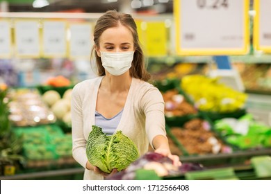 Shopping, Food, Sale, Consumerism And People Concept - Happy Woman In Face Protective Medical Mask For Protection From Virus Disease Buying Savoy At Grocery Store Or Supermarket