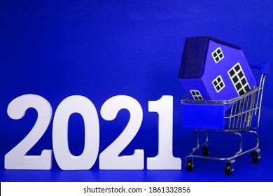 Shopping Home Property 2021 , 2021 Number Wood With House Model On Shopping Cart - Blue Background - Home New Year - Blue Concept Of Real Estate, Property For Sale And Buy