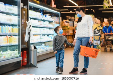 Shopping With Kid During Virus Outbreak. Mother And Child Wearing Surgical Face Mask Buying Fruit In Supermarket. Mom And Little Boy Buy Fresh Vegetable In Grocery Store. Family In Shop.