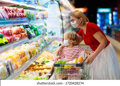 Shopping with kids during virus outbreak. Mother and child wearing surgical face mask buying fruit in supermarket. Mom and little boy buy fresh vegetable in grocery store. Family in shop. 