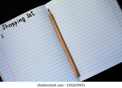 Shopping list on a notebook with a pencil
