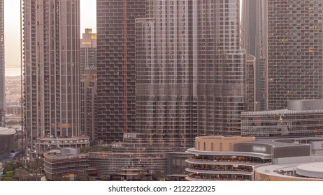 Shopping Mall Exterior With Reastaurants Day To Night Transition Timelapse After Sunset In Dubai, United Arab Emirates. Aerial Top View With Tallest Skyscraper On A Background