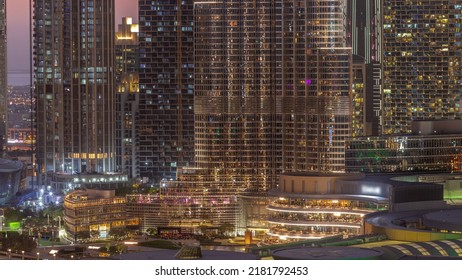 Shopping Mall Exterior With Reastaurants Day To Night Transition Timelapse After Sunset In Dubai, United Arab Emirates. Aerial Top View With Tallest Skyscraper On A Background