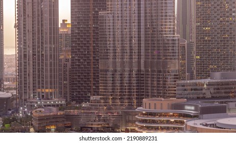 Shopping Mall Exterior With Reastaurants Day To Night Transition Timelapse After Sunset In Dubai, United Arab Emirates. Aerial Top View With Tallest Skyscraper On A Background