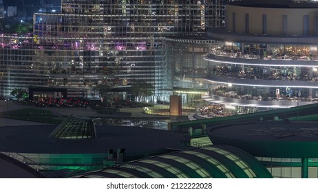 Shopping Mall Exterior With Reastaurants On Balconies Night Timelapse In Dubai, United Arab Emirates. Aerial Top View With Tallest Skyscraper On A Background