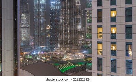 Shopping Mall Exterior With Reastaurants On Balconies Night Timelapse In Dubai, United Arab Emirates. Glowing Windows In Towers. Aerial Top View With Tallest Skyscraper On A Background