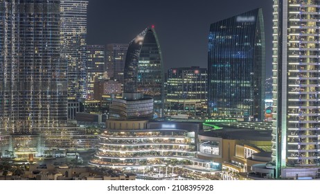 Shopping Mall Exterior With Reataurants Near Fountain In Dubai Downtown Aerial Night Timelapse, United Arab Emirates. Illuminated Skyscrapers Around