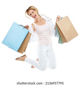 Shopping mayhem in full swing. Studio portrait of an excited young woman carrying shopping bags and jumping for joy against a white background.