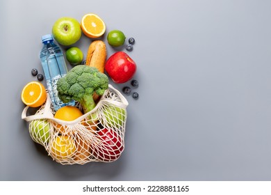 Shopping mesh bag full of healthy food on grey background. Flat lay with copy space - Powered by Shutterstock