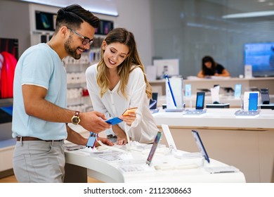 Shopping A New Digital Device. Happy Couple Buying A Smartphone In Store.