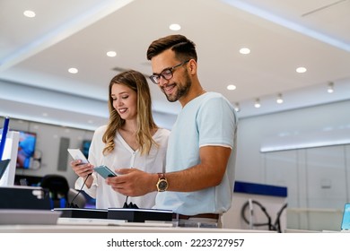 Shopping a new digital device. Happy couple buying a smartphone in store. - Shutterstock ID 2223727957