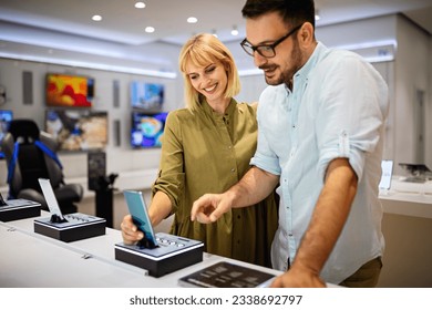 Shopping a new digital device. Happy couple buying a smartphone in store. - Shutterstock ID 2338692797