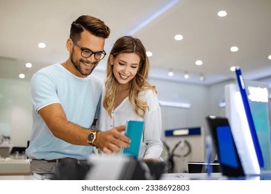 Shopping a new digital device. Happy couple buying a smartphone in store. - Shutterstock ID 2338692803