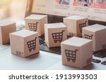 Shopping online. Cardboard box with a shopping cart logo on laptop keyboard. Shopping service on The online web. offers home delivery