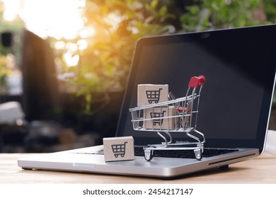 Shopping online. cardboard box with a shopping cart logo in a trolley on laptop keyboard. Shopping service on The online web. offers home delivery - Powered by Shutterstock