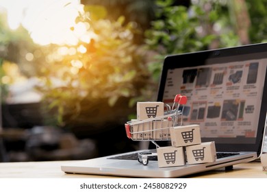 Shopping online. cardboard box with a shopping cart logo in a trolley on laptop keyboard. Shopping service on The online web. offers home delivery - Powered by Shutterstock