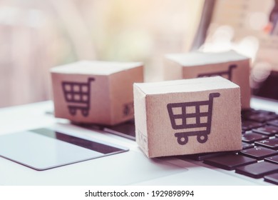 Shopping Online. Credit Card And Cardboard Box With A Shopping Cart Logo On Laptop Keyboard. Shopping Service On The Online Web. Offers Home Delivery