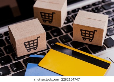 Shopping online. Credit card and cardboard box with a shopping cart logo on laptop keyboard. Shopping service on The online web. offers home delivery - Shutterstock ID 2282154747