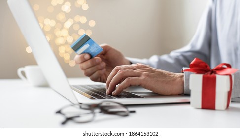 Shopping Online During Holidays. Man Using Laptop Computer And Credit Card, Ordering Christmas Gifts. Shopping, Internet Banking, Store Online, Payment, Surprise, Spending Money, Holidays Concept