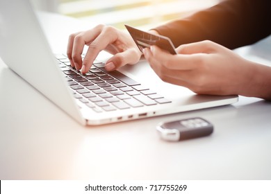 Shopping And Online Payment By Using Laptop And Car Key On Table With Sun Light Effect