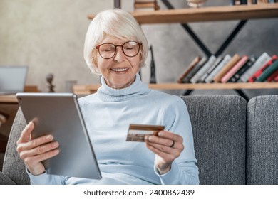 Shopping online. Senior woman using tablet computer and credit card. E-commerce, e-banking, bank account debt, mortgage, pension receiving. Cashless payment - Powered by Shutterstock