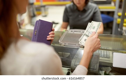 shopping, payment, consumerism and people concept - woman paying money and cashier at store cash register
