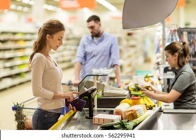 Shopping, Sale, Consumerism, Cashless Payments And People Concept - Happy Woman Buying Food At Grocery Store Or Supermarket Cash Register