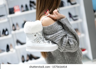 Shopping at a shoe store. A young girl buys shoes. Happy shopper. Product close up