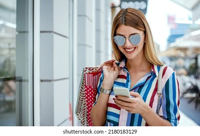 Shopping Time. Modern Young Woman Making A Video Call With Mobile Phone During The Shopping In The City. Consumerism, Lifestyle Concept