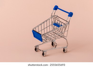 Shopping trolley with blue handle and blue basket. Copy space. - Powered by Shutterstock