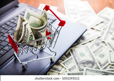 Shopping Trolley With Dollars On A Laptop. Online Sale.