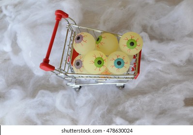 Shopping Trolley Fulled With Fake Eyeballs With Spider Web Background