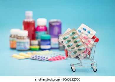 Shopping Trolley With Medicines Pill Blister For Online Shopping On Blue Background. Medicine Online Purchase , Order And Delivery Concept. 