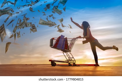 Shopping Woman In Action Of Chasing Money Spending With  Shopping Cart Pushing, Consumption A Lot Of Money Of Shopping Woman Concept