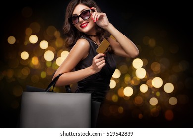 Shopping woman holding grey bag on new year background with lights bokeh in black friday holiday - Powered by Shutterstock