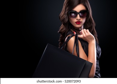 Shopping woman holding grey bag isolated on dark background in black friday holiday - Powered by Shutterstock