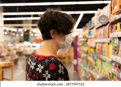 Shopping Woman Wearing Medical Mask Short Hair At The Grocery Store For Christmas Or New Year Dinner Table. Ugly Christmas Sweater. Coronavirus Times Pandemic. Blurry Photo. Diversity. Social Distance