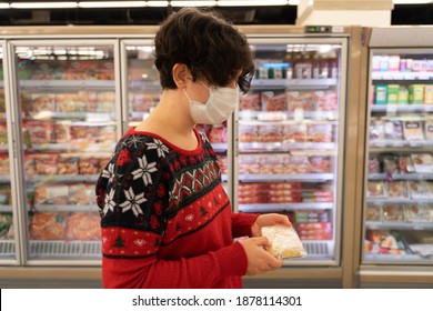 Shopping Woman Wearing Medical Mask Short Hair At The Grocery Store For Christmas Or New Year Dinner Table. Cheese, Ugly Christmas Sweater. Coronavirus Times Pandemic. Blurry Photo. Diversity. 2021